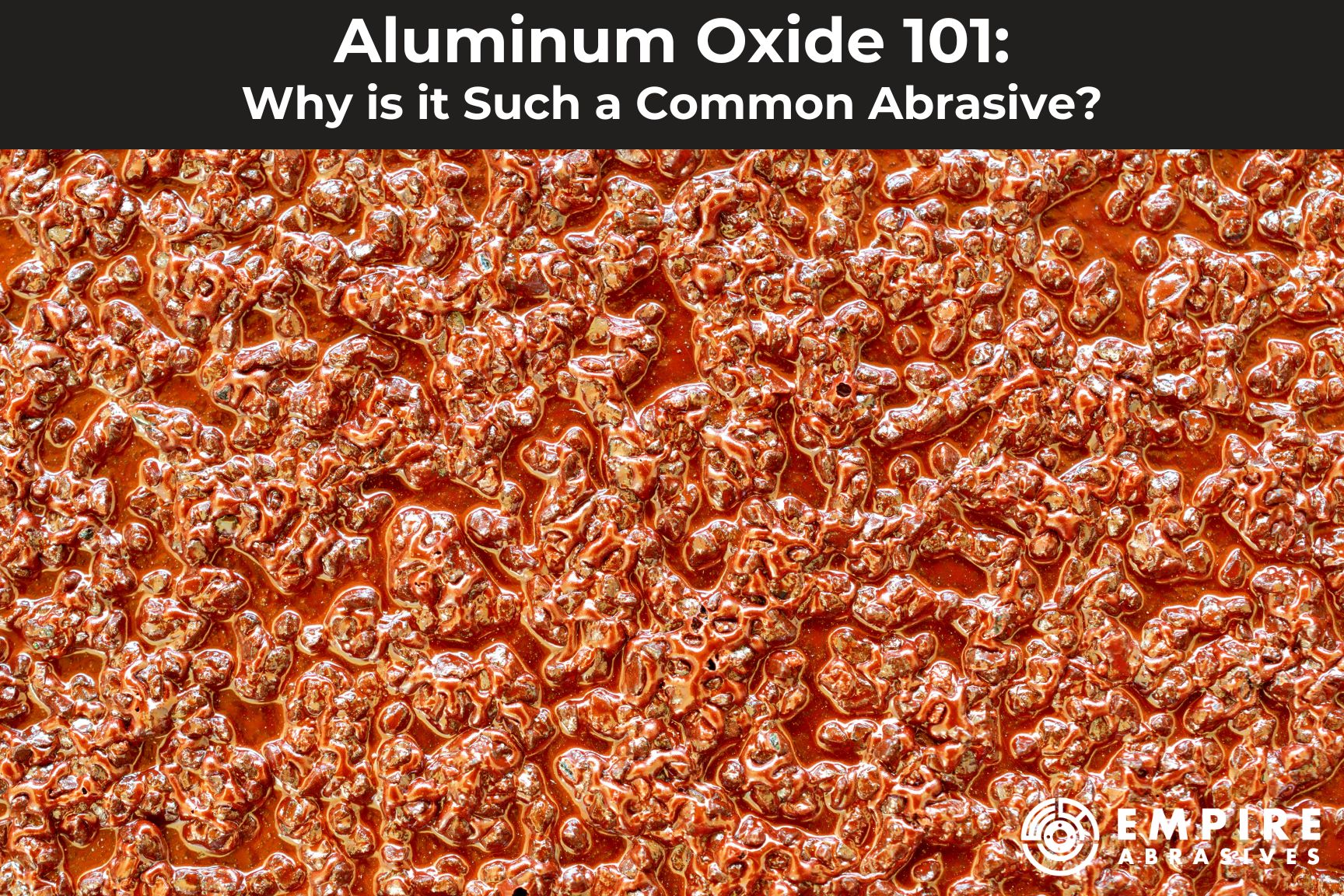Blog post header for "Aluminum Oxide 101:Why is it Such a Common Abrasive?" by Empire Abrasives featuring a close up image of aluminum oxide grains.
