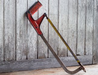 Traditional metal hacksaw with a long blade ready for rebar cutting projects