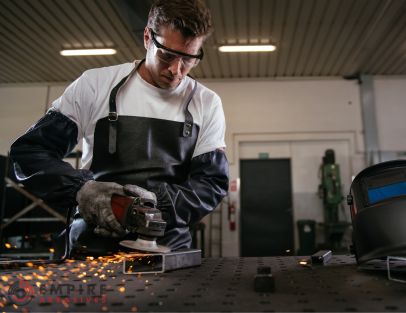 Safety-conscious worker in apron using abrasive tools, as recommended for body protection by Empire Abrasives.