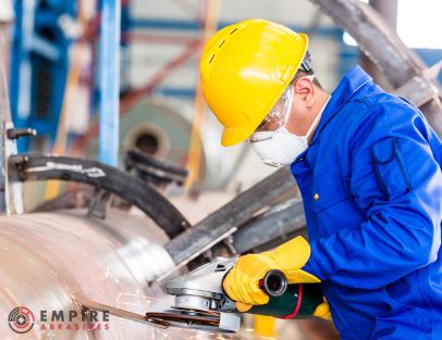 Industrial worker using respirator and PPE for hazardous grinding tasks