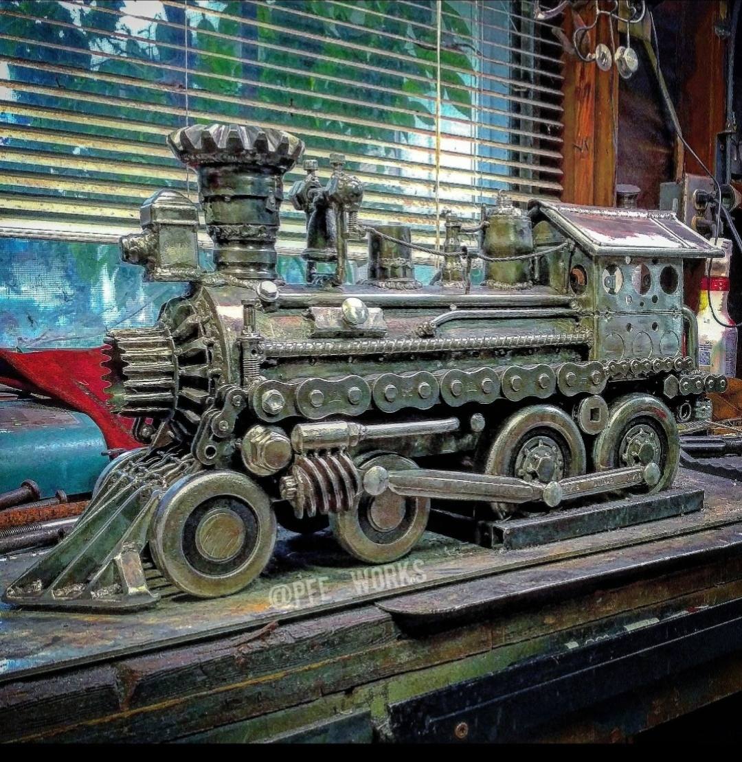 Metal art train sculpture using scrap metal parts and chainsaw chains, created by metal artist PJ Kennedy aka PFe works