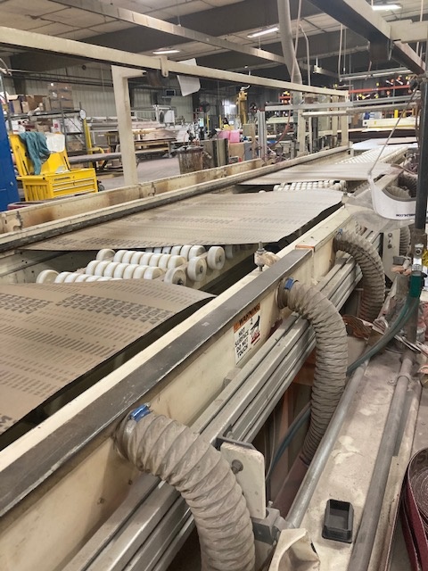 Wide sanding belt rolling out on factory line